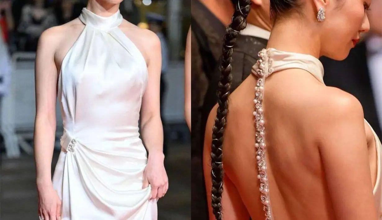 Jeon Yeo Been bersama Krystal Jung melakukan debut bersama di Cannes Film Festival 2023. Ia tampil mengenakan halter-neck backless dress berwarna putih satin yang menawan. Di bagian belakang gaunnya memiliki garis lurus taburan berlian yang cantik. Penampilan Yeo Been memukau dengan rambut yang ditata sleek-look, dikepang satu dan diikat pony-tail. Foto: Instagram.