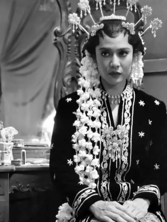 Dalam sebuah potret hitam putih, Dian Sastro terlihat mengenakan kebaya pengantin. Kebaya pengantin Jawa yang klasik dan megah ini juga terlihat memesona ketika dikenakan Dian Sastro di serial Gadis Kretek. [Foto: Instagram/thebridedept]