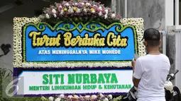 Karangan bunga dari Menteri LHK, Siti Nurbaya terpampang di rumah duka Mike Mohede di kawasan Tangerang Selatan, Banten, Senin (1/8). Mike Mohede meninggal dunia di usia 32 tahun karena serangan jantung. (Liputan6.com/Herman Zakharia)