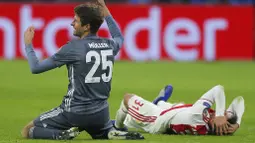 Bek Ajax Amsterdam, Nicolas Tagliafico, memegang kepala usai ditendang gelandang Bayern Munchen, Thomas Mueller, pada laga Liga Champions di Johan Cruyff Arena, Amsterdam, Rabu (12/12). Kedua tim bermain imbang 3-3. (AP/Peter Dejong)