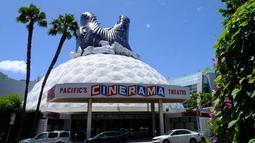 Sejumlah kendaraan terparkir depan bioskop Cinerama Dome yang atapnya dihiasi godzilla raksasa di Hollywood, California, AS pada 20 Mei 2019. Hinggapnya godzilla raksasa untuk menyambut sekuel Godzilla: King of the Monsters yang akan dirilis pada 31 Mei 2019. (Photo by Chris Delmas / AFP)