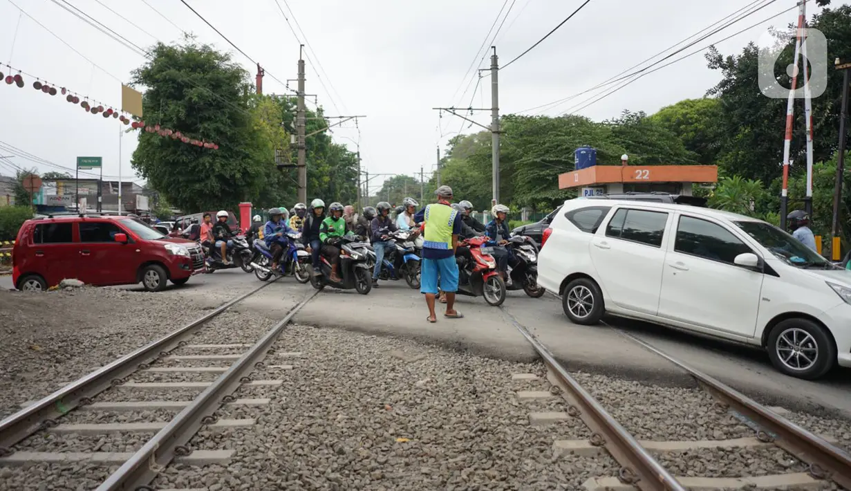 Kendaraan melewati perlintasan sebidang yang juga merupakan jalur putar balik di kawasan Lenteng Agung, Jakarta, Kamis (14/11/2019). Mulai 15 November 2019, jalur putar balik tersebut akan ditutup terkait pembangunan flyover yang saat ini telah mulai dikerjakan. (Liputan6.com/Immanuel Antonius)