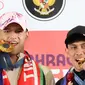 Dua atlet Indonesia peraih medali emas di Olimpiade 2024 Paris Rizki Juniansyah (kiri) dan Veddriq Leonardo (kanan) berpose menggigit medali emasi usai tiba di Bandara Internasional Soekarno-Hatta, Tangerang, Selasa (13/8/2024) (Abdul Aziz/Bola.com).&nbsp;