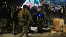 Petugas polisi Israel membubarkan pria Yahudi ultra-Ortodoks yang menghalangi jalan dalam aksi protes menentang rencana wajib militer mereka di militer Israel, di Yerusalem, Kamis 30 Oktober 2025. Sebelumnya, puluhan ribu pria ultra-Ortodoks memenuhi pintu masuk ke Yerusalem dalam lautan hitam pada Kamis (30/10/2025) untuk memprotes rencana wajib militer bagi mereka. (AP Photo/Ohad Zwigenberg)