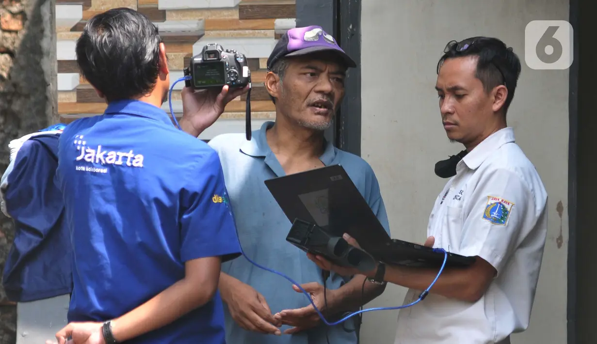 Disabilitas Orang dengan Gangguan Jiwa (ODGJ) Suriadi (53, tengah) melakukan rekam KTP Elektronik di Jalan Waru RT 004/RW 02 Cilangkap, Jakarta Timur Rabu (15/5/2024). (merdeka.com/Imam Buhori)