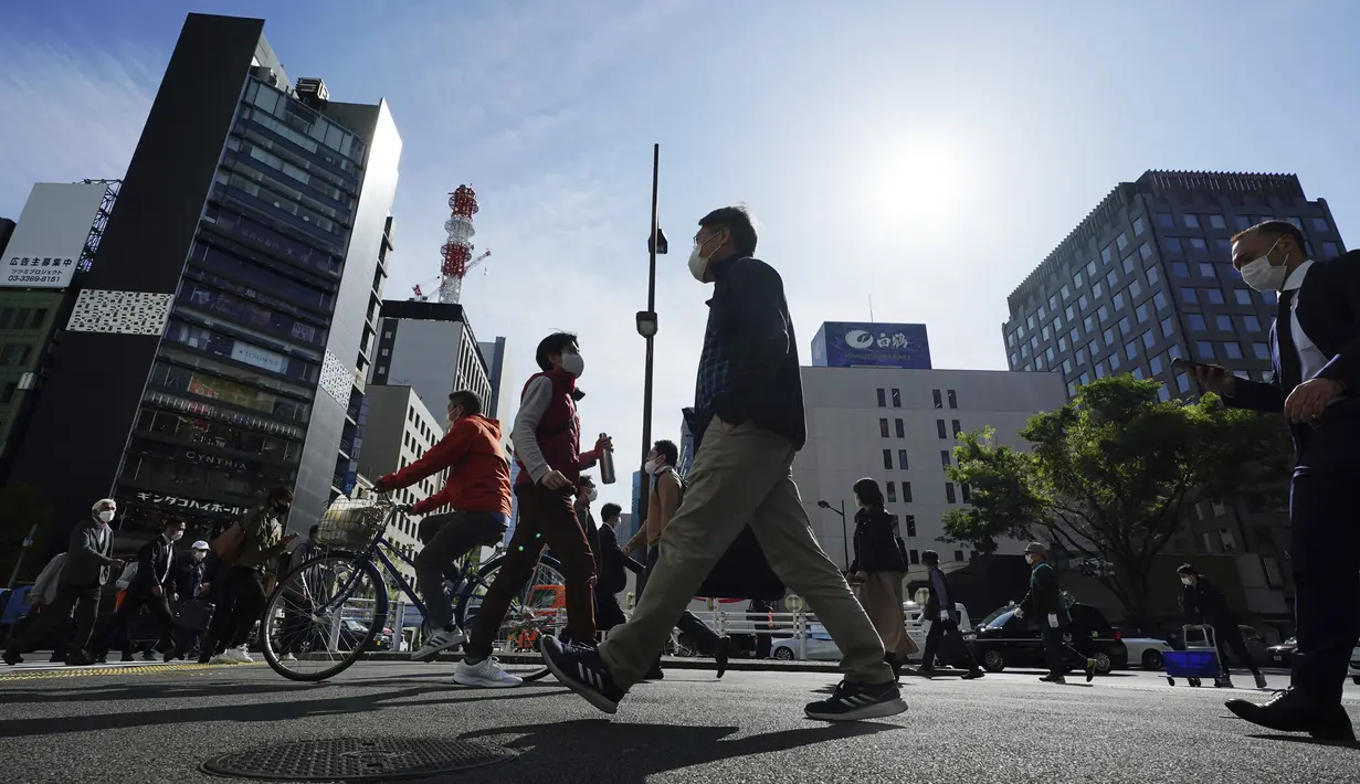 Orang-orang yang mengenakan masker pelindung untuk membantu mengekang penyebaran virus corona COVID-19 berjalan di Tokyo, Jepang, Kamis (15/4/2021). Tokyo mengonfirmasi lebih dari 700 kasus baru COVID-19 pada 15 April 2021. (AP Photo/Eugene Hoshiko)