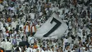 Suporter Real Madrid mengibarkan bendera raksasa saat melawan Dortmund pada laga Liga Champions di Stadion Santiago Bernabeu, Madrid, Rabu (6/12/2017). Madrid menang 3-2 atas Dortmund. (AP/Paul White)