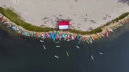 Foto udara memperlihatkan para penggemar kayak sedang mengibarkan bendera Merah Putih sebagai bagian dari perayaan Hari Ulang Tahun (HUT) ke-78 Republik Indonesia (RI) di sebuah pulau kecil di Teluk Jakarta, Jakarta, Kamis (17/8/2023). (BAY ISMOYO/AFP)
