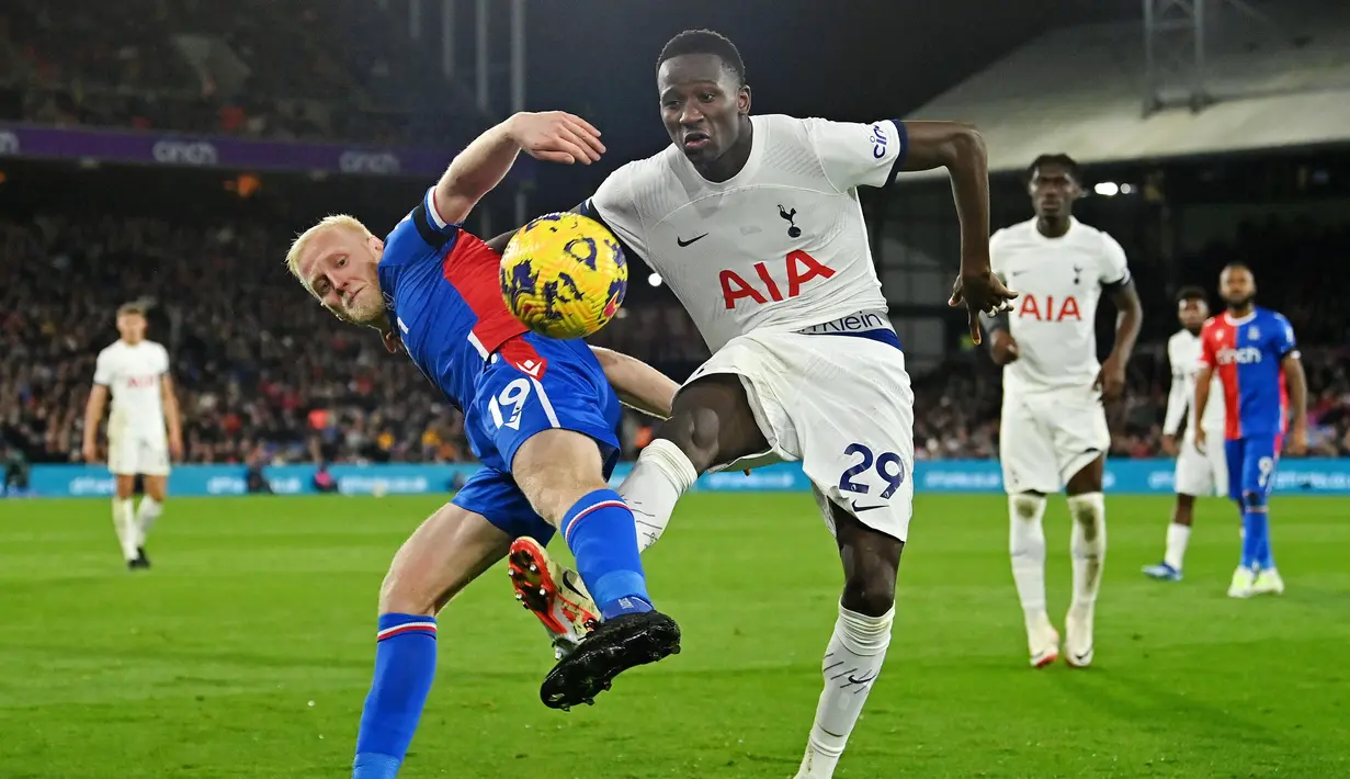 Pemain Tottenham Hotspur, Pape Matar Sarr, berebut bola dengan pemain Crystal Palace, Will Hughes, pada laga Liga Inggris di Stadion Selhurst Park Sabtu (28/10/2023). (AFP/Glyn Kirk)