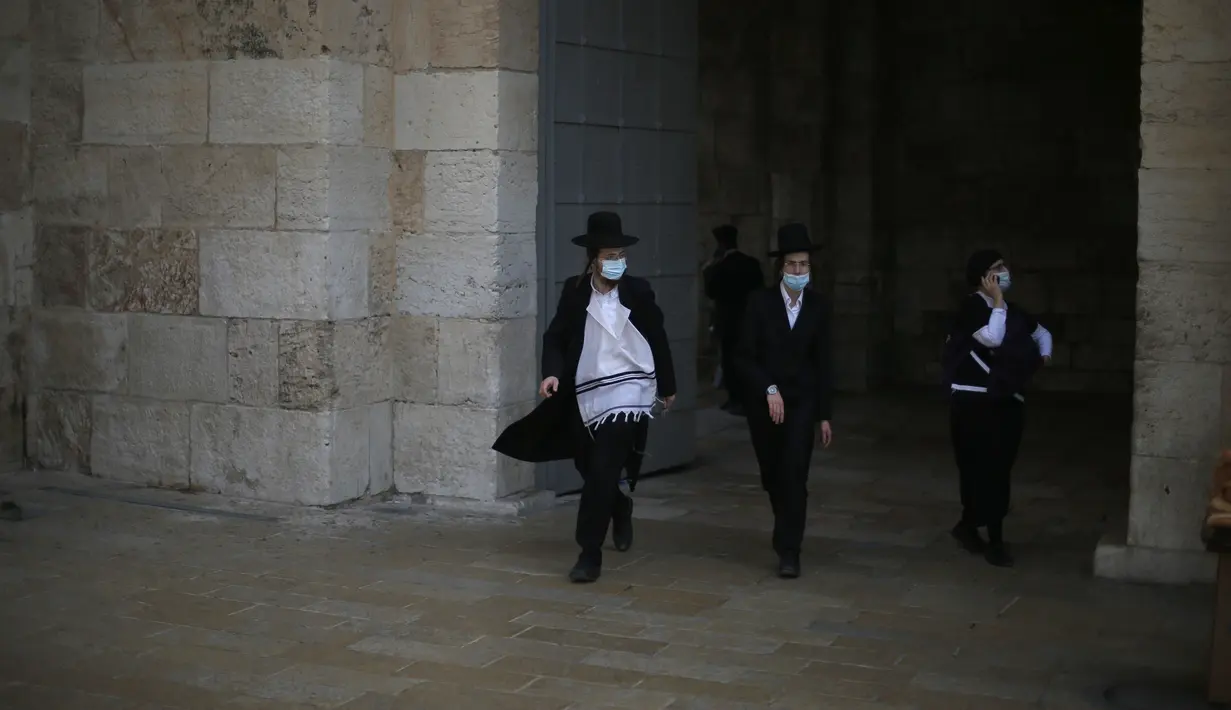 Orang-orang yang mengenakan masker terlihat di luar Kota Tua Yerusalem di tengah pandemi COVID-19 (25/11/2020). (Xinhua/Muammar Awad)