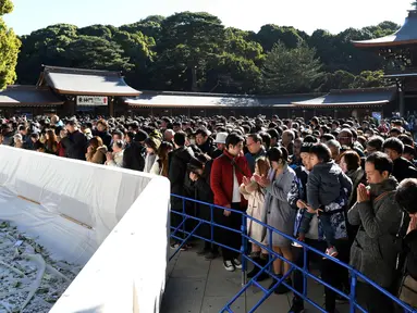 Warga memanjatkan doa Tahun Baru 2018 di Kuil Meiji, Tokyo, Jepang (1/1). Jutaan warga Jepang mengunjungi kuil-kuil di seluruh negeri selama tiga hari pertama tahun baru untuk berdoa demi kesejahteraan keluarga mereka. (AFP Photo/Kazuhiro Nogi)