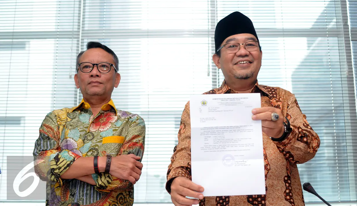 Ketua BPK RI, Harry Azhar Azis (kanan) menunjukkan surat pemanggilan dirinya oleh Dirjen Pajak di Jakarta, Jumat (15/4/2016). Harry dipanggil untuk melakukan klarifikasi SPT SPT Tahunan PPh Op 2015. (Liputan6.com/Helmi Fithriansyah)
