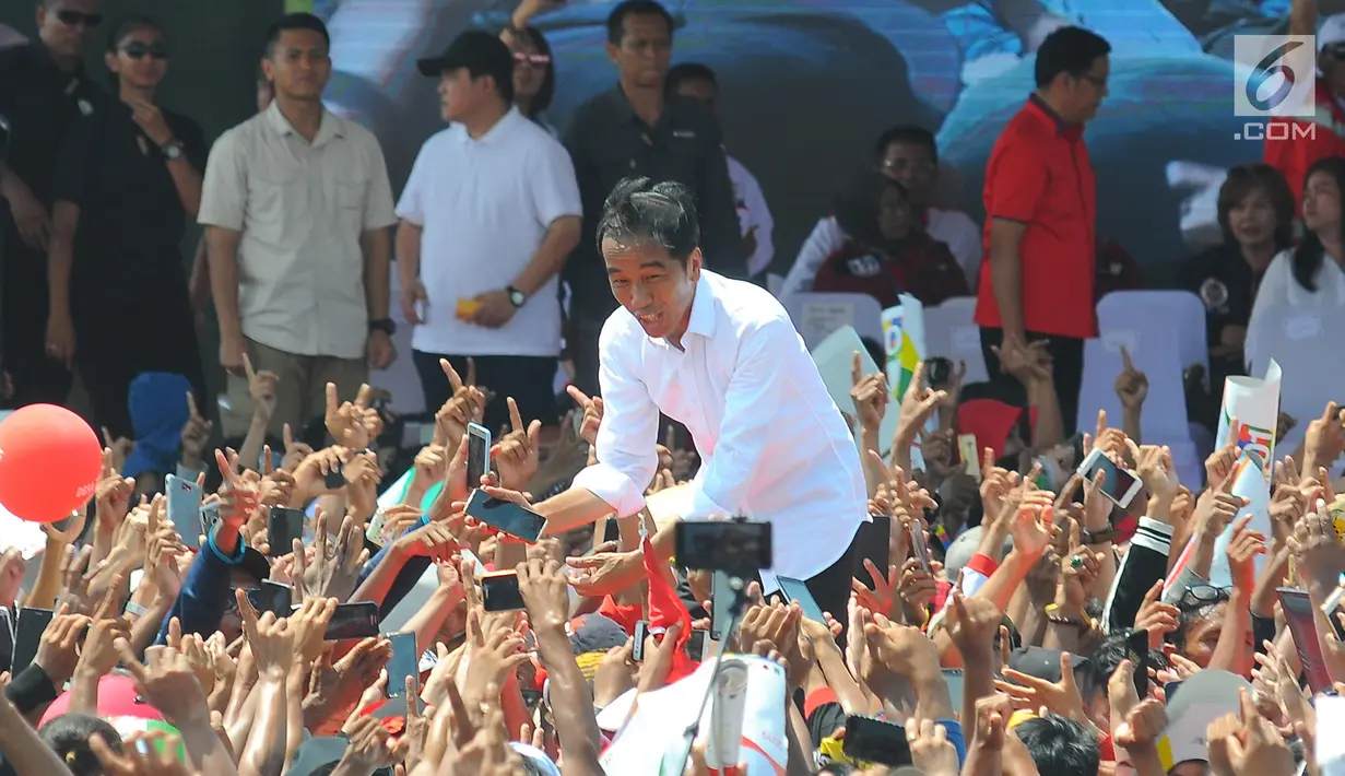 Capres 01 Joko Widodo menyapa pendukungnya saat kampanye terbuka di Kabupaten Cirebon, Jumat (5/4). Jokowi mengajak masyarakat Cirebon, untuk datang ke TPS dan meminta masyarakat untuk mencoblos surat suara yang fotonya memakai baju putih. (Liputan6 com/Angga Yuniar)