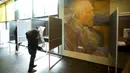 Seorang pemilih membuka surat suaranya saat memberikan suara dalam pemilihan umum di Museum Van Gogh, Amsterdam, Belanda, Rabu (17/3/2021). Pemilu digelar selama tiga hari untuk memungkinkan warga memilih dengan aman selama pandemi virus corona COVID-19. (AP Photo/Peter Dejong)