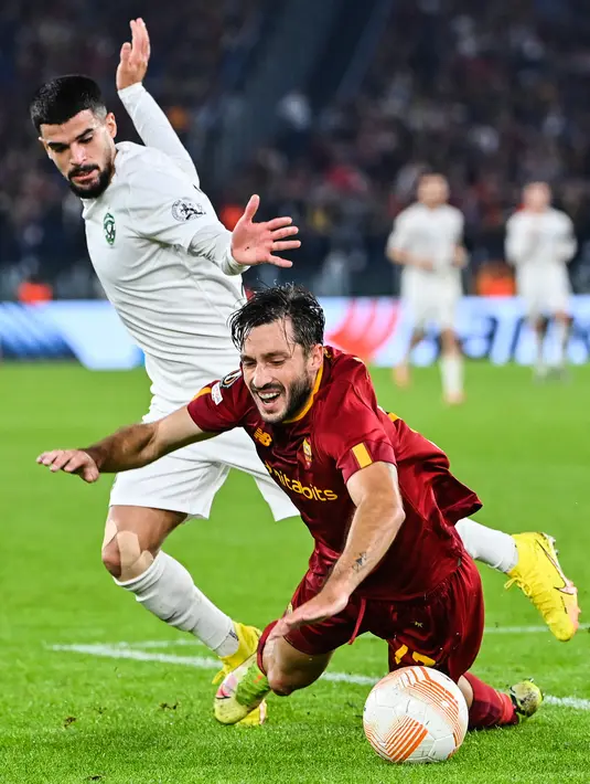 Gelandang Ludogorets Razgrad, Cauly Oliveira Souza (kiri) menjegal bek AS Roma Matias Vina  pada Matchday 6 Grup C Liga Eropa 2022-2023 di Olimpico, Jumat (4/10/2022) dini hari WIB. Sementara itu, Ludogorets turun kasta ke ajang UEFA Europa Conference League. (Alberto PIZZOLI / AFP)
