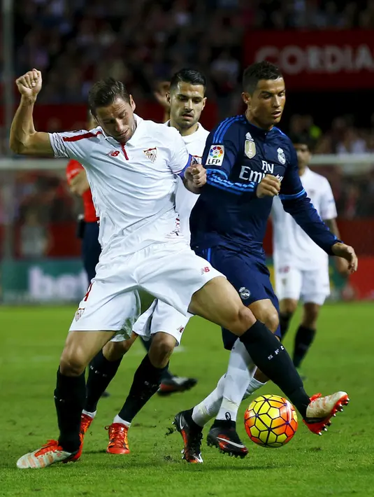Gelandang Sevilla, Grzegorz Krychowiak (kiri) berusaha menghalau bola yang dibawa Cristiano Ronaldo pada lanjutan La Liga di Estadio Ramon Sanchez Pizjuan, Spanyol (9/11/2015). Sevilla menang atas Real Madrid dengan skor 3-2. (REUTERS/Marcelo del Pozo)