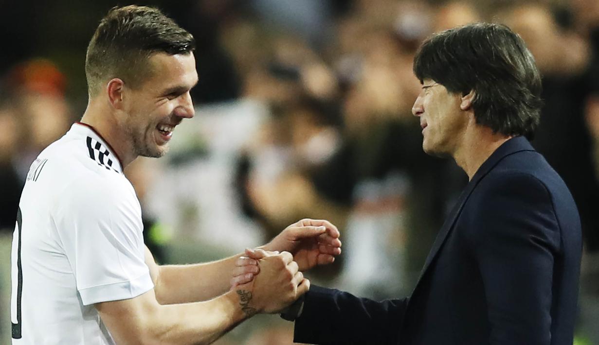 Gelandang Jerman, Lukas Podolski, berbincang dengan pelatih Jerman, Joachim Loew. Podolski turut menjadi bagian dari skuat Jerman saat menjuarai Piala Dunia 2014 di Brasil. (EPA/Friedmann Vogel)