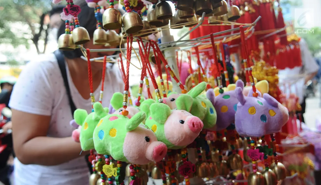 Boneka bertema Imlek dijual di kawasan Glodok, Jakarta, Kamis (31/1). Pernak-pernik Imlek bershio babi tanah sudah mulai ramai dijual. (Liputan6.com/Herman Zakharia)