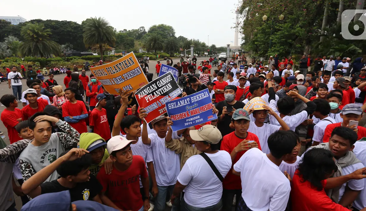 Massa yang tergabung dalam Masyarakat Penegak Demokrasi (MPD) menggelar aksi damai "Menyambut Pelantikan Presiden dan Wapres RI Terpilih" di Kawasan Patung Kuda, Jakarta, Kamis (10/10). Mereka mengimbau masyarakat menjaga situasi aman dan damai jangan terprovokasi. (Liputan6.com/Herman Zakharia)
