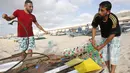 Nelayan Palestina, Mouad Abu Zeid memperbaiki perahunya yang terbuat dari botol plastik bekas di pantai Rafah, Jalur Gaza, 14 Agustus 2018. Sejak Israel memblokade Gaza, banyak warga yang kehilangan mata pencaharian dan beralih profesi. (AFP/SAID KHATIB)