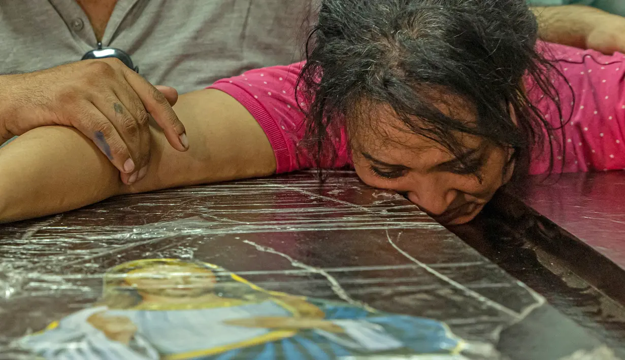 Seorang wanita menangis saat pemakaman korban tewas dalam kebakaran gereja kristen koptik di Gereja Santa Perawan Maria, Kairo, Provinsi Giza, Mesir, 14 Agustus 2022. Sebanyak 18 korban tewas adalah anak-anak usia 3 sampai 16 tahun. (Khaled DESOUKI/AFP)