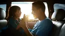 Seorang anak dan ayah sedang bermain di dalam mobil, terlihat mereka berdua tersenyum lebar dan begitu bahagia yang menggambarkan kedekatan mereka. (Odua Images/ Shutterstock.com)
