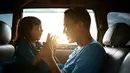 Seorang anak dan ayah sedang bermain di dalam mobil, terlihat mereka berdua tersenyum lebar dan begitu bahagia yang menggambarkan kedekatan mereka. (Odua Images/ Shutterstock.com)