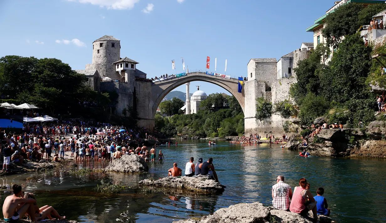 Para penonton menyaksikan aksi peserta pria melompat dari jembatan saat mengkuti acara kompetisi menyelam tradisional 450 di Mostar, Bosnia dan Herzegovina, (31/7). (REUTERS/Dado Ruvic)