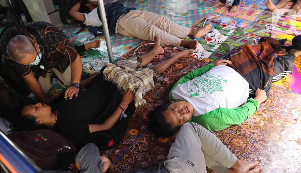 Tim Dokter Rumah Sakit Pena 98 melakukan pemeriksaan medis terhadap peserta mogok makan di Komnas HAM, Jakarta, Minggu (18/12/2022). Sebanyak 5 peserta mogok makan yang melawan atas tindak kejahatan PT. Amman Mineral terhadap masyarakat Sumbawa Barat, tumbang akibat mengalami penurunan kesehatan dan dilarikan ke rumah sakit terdekat untuk mendapatkan perawatan medis. (Liputan6.com/Herman Zakharia)