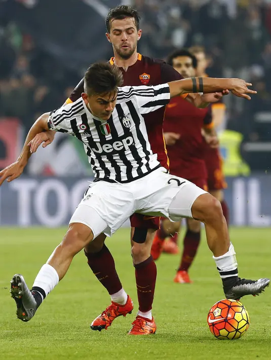 Penyerang Juventus, Paulo Dybala (depan) mengontrol bola dari kawalan gelandang AS Roma, Miralem Pjanic pada lanjutan liga serie A Italia di Juventus Stadium, Turin (24/1/2016). Juventus menang dengan skor 1-0. (REUTERS/Stefano Rellandini)