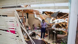 Seorang warga berada di rumah yang rusak akibat dihantam Tornado di Monroe, La, Minggu (12/4/2020). Layanan Cuaca Nasional (NWS) AS sebelumnya mengeluarkan peringatan darurat ke level tertinggi karena tornado berpotensi menyebabkan kehancuran yang parah. (Nicolas Galindo/The News-Star via AP)