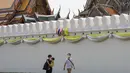 Turis berjalan di luar kompleks bangunan Grand Palace di Bangkok, 8 Maret 2020. Jumlah kedatangan turis ke Thailand tahun ini diperkirakan turun hingga 6 juta, terendah dalam empat tahun terakhir, menurut Otoritas Pariwisata Thailand (TAT) dalam konferensi pers baru-baru ini. (Xinhua/Zhang Keren)