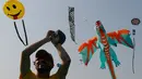 Seorang peserta menerbangkan layang-layang berbentuk naga saat festival layang-layang Internasional di Ahmadabad, India (7/1). Acara ini menarik banyak penonton dari India dan negara lainnya. (AP Photo/Ajit Solanki)