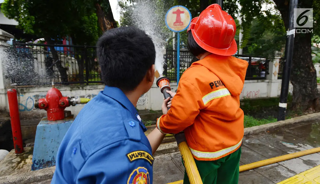 Petugas pemadam kebakaran mengajari anak TK cara memadamkan api di Jakarta, Kamis (21/3). Kegiatan ini bertujuan mengenalkan profesi pemadam kebakaran dan memberi pengetahuan proses pemadaman api kepada anak usia dini. (merdeka.com/Imam Buhori)