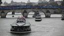 Kontingen Indonesia bersama kontingen India dan Iran berlayar di atas perahu saat upacara pembukaan Olimpiade Paris 2024 di Sungai Seine, Paris Prancis, 26 Juli 2024. (AFP/Sebastien Bozon)