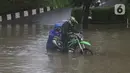 Kendaraan pengendara mogok saat memaksa melintasi Jalan Di Panjaitan dekat Halte Transjakarta Cawang Soetoyo yang banjir, Jakarta, Rabu (1/1/2020). Hujan yang mengguyur Jakarta sejak Selasa sore (31/12/2019) mengakibatkan banjir di sejumlah titik di Jakarta. (Liputan6.com/Helmi Fithriansyah)