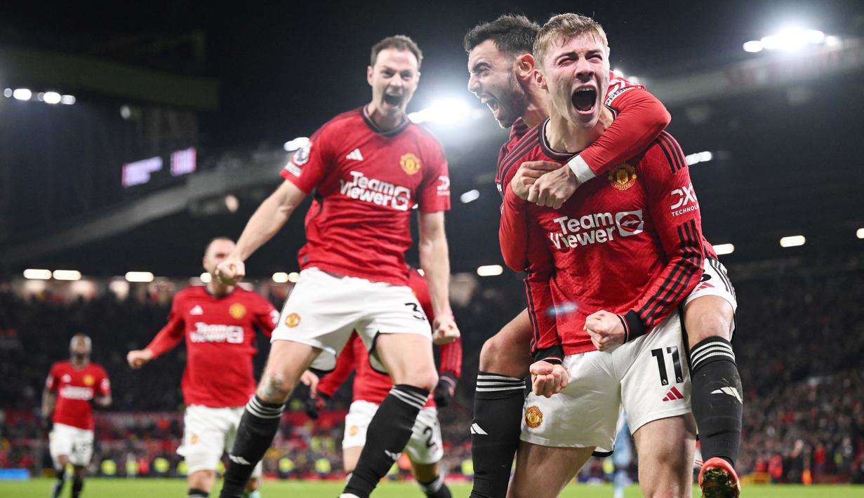 Pemain Manchester United, Rasmus Hojlund, melakukan selebrasi setelah mencetak gol ke gawang Aston Villa pada pekan ke-19 Premier League 2023/2024 di Stadion Old Trafford, Rabu (27/12/2023). Hojlund tampak begitu emosional merayakan gol perdananya tersebut. (AFP/Oli Scarff)