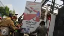 Petugas Satpol PP menurunkan papan reklame rokok di Jakarta, Rabu (18/11). Gubernur DKI Jakarta menerbitkan Peraturan Gubernur Nomor 1 Tahun 2015 tentang Larangan Penyelenggaraan Reklame Rokok Media Luar Ruang. (Liputan6.com/Gempur M Surya)