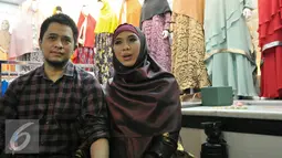 Oki Setiana Dewi bersama suami memberikan keterangan saat peresmian toko busana muslimnya yang ke-4 di Tanah Abang, Jakarta, Rabu (2/12). Memasuki kehamilan 7 bulan, Oki justru semakin aktif dengan membuka toko baju Muslimnya. (Liputan6.com/Yoppy Renato)