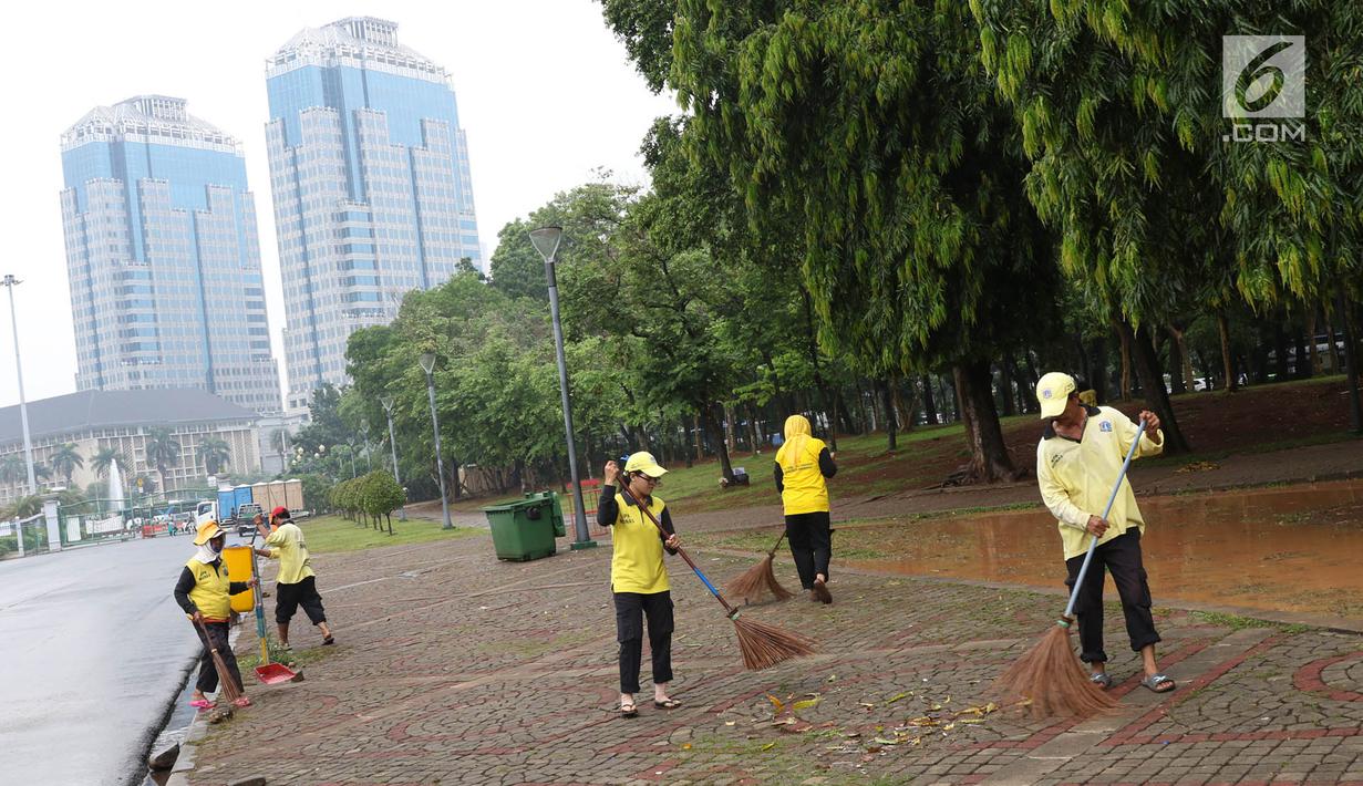 Petugas menyapu sampah yang tercecer di kawasan Monas, Jakarta, Senin (3/11). Kesigapan petugas kebersihan pasca reuni 212 membuat kawasan tersebut kembali bersih meskipun sehari sebelumnya dipenuhi ratusan ribu orang. (Liputan6.com/Immanuel Antonius)
