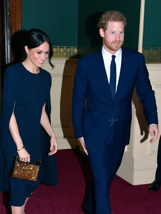 Pangeran Harry bersama tunangannya, Meghan Markle menghadiri konser perayaan ulang tahun Ratu Elizabeth di London, Sabtu (21/4). Penampilan Meghan Markle terlihat serasi dengan busana yang dikenakan Pangeran Harry. (John Stillwell/Pool via AP)