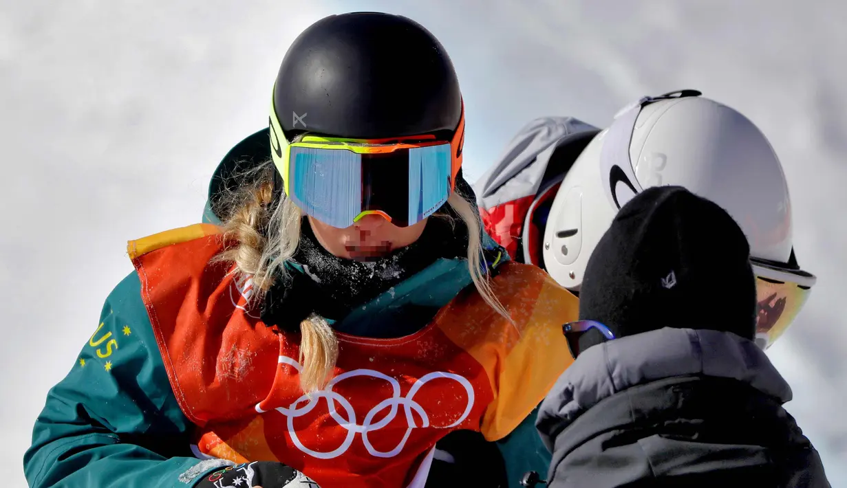 Atlet Snowboarding dari Australia, Emily Arthur mendapat perawatan setelah terjatuh dalam pertandingan semifinal halfpipe putri pada Olimpiade Musim Dingin 2018 di Pyeongchang, Korea Selatan, (13/2). (AP Photo / Gregory Bull)