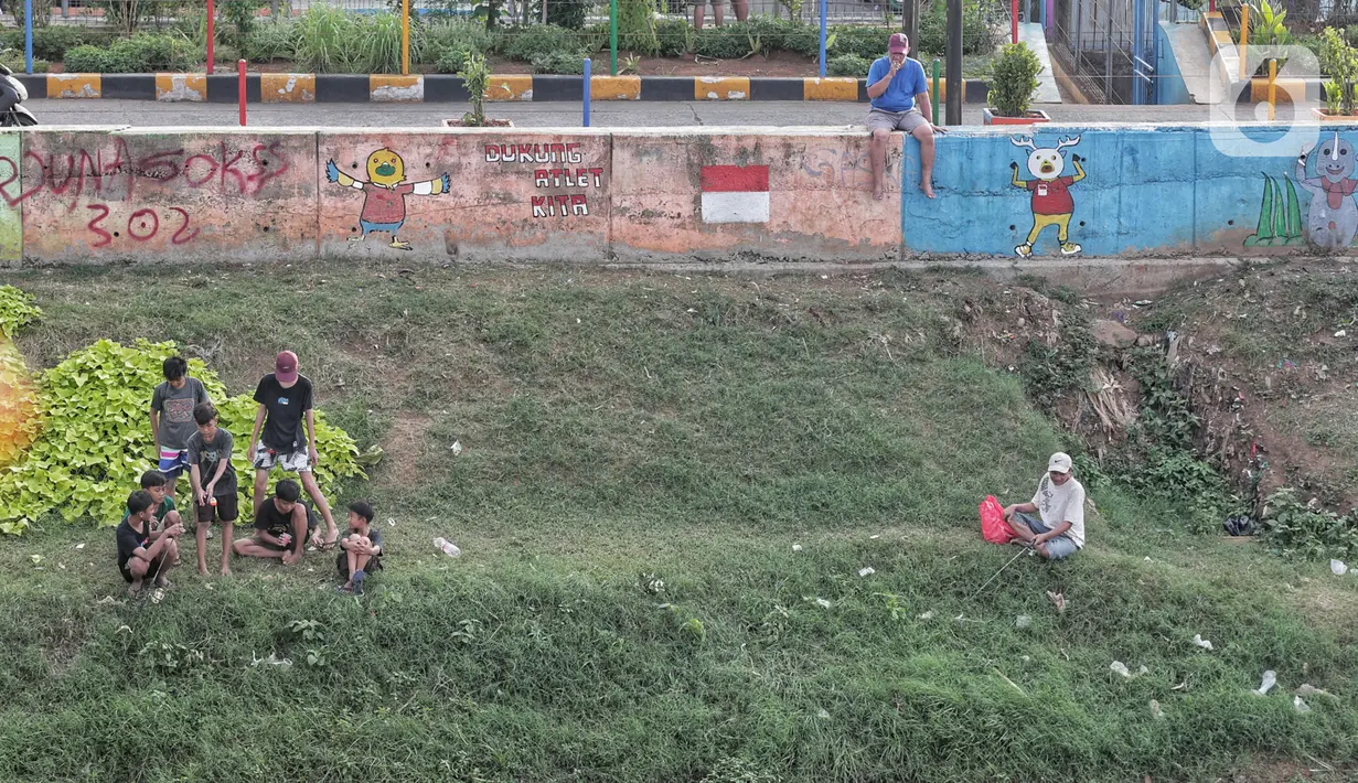Warga melakukan aktivitas mancing di Kanal Banjir Barat, Jakarta, Selasa (9/6/2020). Fase pertama PSBB transisi di Ibukota dimanfaatkan warga untuk memancing. (Liputan6.com/Johan Tallo)