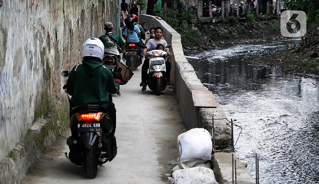 Sejumlah pengendara sepeda motor melintasi jalur alternatif di belakang Kompleks Patra Jasa, Jakarta Selatan, Rabu (1/3/2023). Jalur alternatif seperti gang, jalan kecil, maupun jalan tembusan menjadi pilihan bagi pengendara sepeda motor untuk menghindari kemacetan di jalan-jalan protokol Ibu Kota. (Liputan6.com/Johan Tallo)