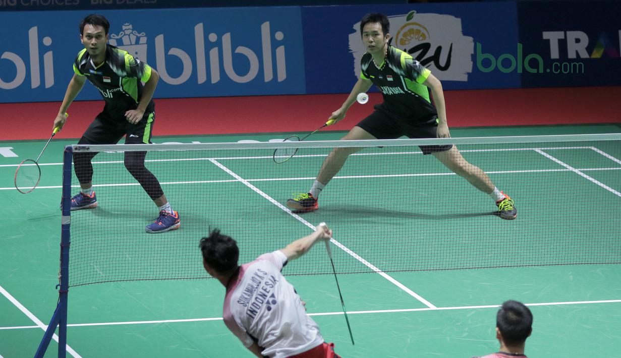 Kevin Sanjaya melepaskan smash ke arah Hendra Setiawan/M. Ahsan pada babak pertama Indonesia Open 2018 di Istora Senayan, Jakarta, (4/6/2018). Kevin/Marcus menang 21-16 18-21 21-10.  (Bola.com/Nick Hanoatubun)