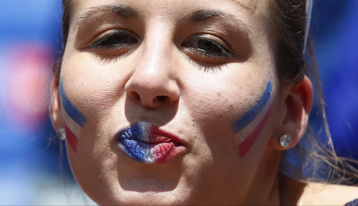 Fans asal Prancis dengan bibir dan pipi bermotif bendera menanti laga Prancis melawan Rep. Irlandia pada babak 16 besar Piala Eropa 2016 di Stade de Lyon, Lyon, Prancis,(26/6/2016). (REUTERS/Kai Pfaffenbach)