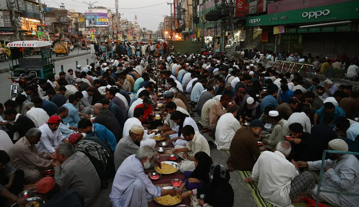 Umat Islam Pakistan berbuka puasa bersama di sepanjang jalan di Rawalpindi pada 7 Mei 2019. Ketika bulan suci Ramadan mulai di Pakistan, banyak masyarakat muslim memanfaatkan buka puasa gratis yang disponsori oleh badan-badan amal dan orang-orang kaya. (RIZWAN TABASSUM / AFP)