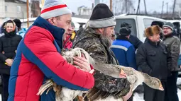 Dua pria membawa angsa mereka selama pertarungan angsa tradisional di desa Kalikino sekitar 450 km di luar Moskow, Rusia (17/3). (AFP Photo/Vasily Maximov)