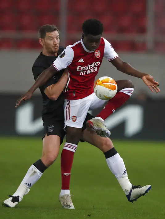 Pemain Arsenal Bukayo Saka (kanan) mengontrol bola di depan pemain Benfica Jan Vertonghen pada leg kedua babak 32 besar Liga Europa di Stadion Georgios Karaiskakis, Piraeus, Athena, Yunani, Kamis (25/2/2021). Arsenal menang 3-2 dan lolos ke babak 16 besar. (AP Photo/Thanassis Stavrakis)