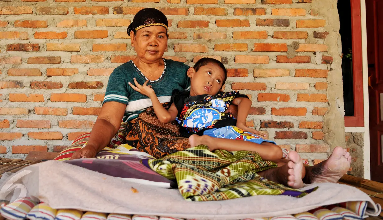 Indrawan saat digendong neneknya untuk bersantai didepan rumah, Kampung Katimaha, Bekasi, Jawa Barat, (11/7).Waktu diperiksa umur bocah itu baru 3 bulan dan perilakunya berbeda dengan bocah normal lainnya. (Liputan6.com/Gempur M Surya)